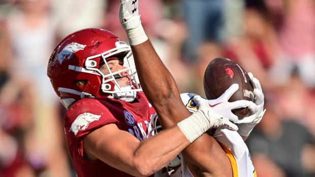 Razorbacks wide receiver Isaac TeSlaa makes a leaping grab over a Kent State defender
